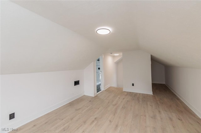 additional living space with lofted ceiling and light hardwood / wood-style floors