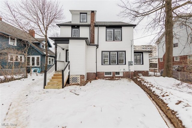 view of snow covered rear of property