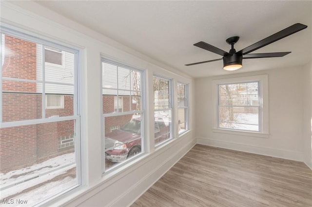 unfurnished sunroom featuring ceiling fan