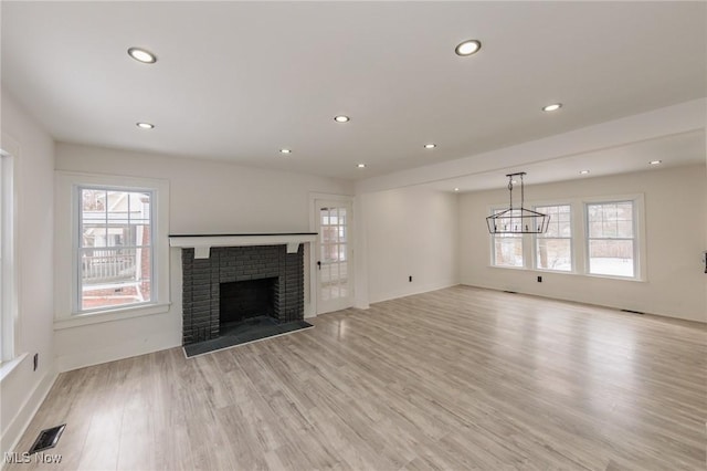 unfurnished living room with a fireplace and light hardwood / wood-style flooring