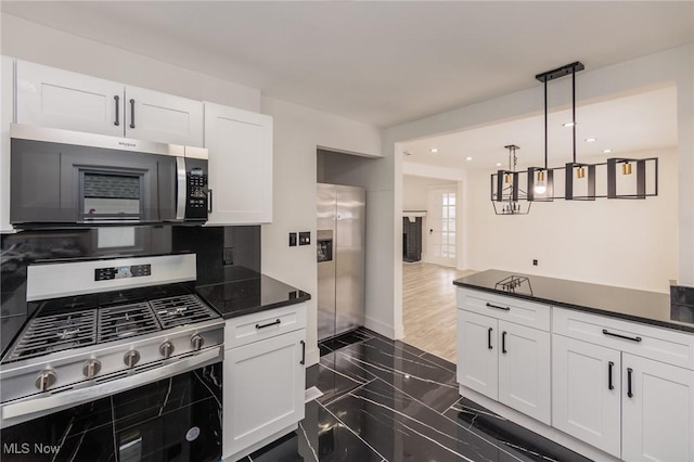 kitchen featuring pendant lighting, stainless steel appliances, and white cabinets