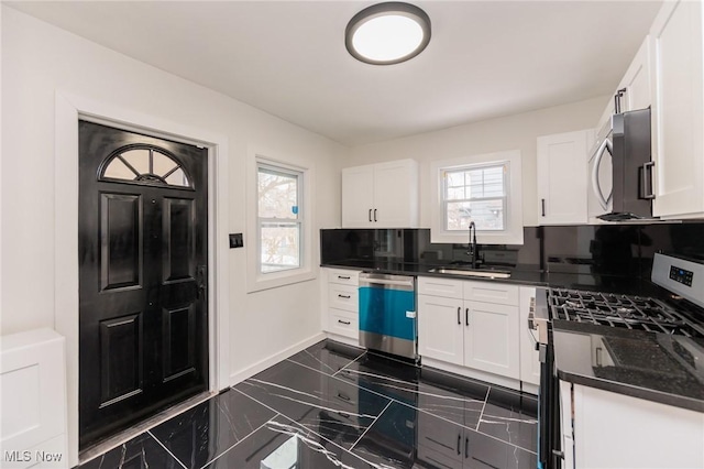 kitchen with white cabinetry, appliances with stainless steel finishes, and sink