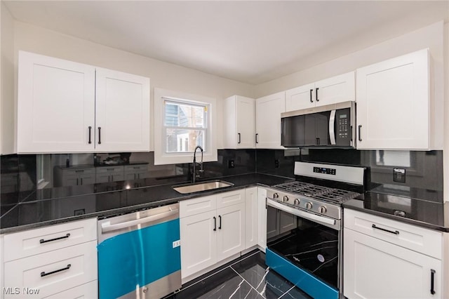 kitchen with white cabinetry, appliances with stainless steel finishes, sink, and backsplash