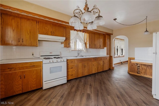 kitchen featuring pendant lighting, sink, white appliances, dark hardwood / wood-style floors, and tasteful backsplash