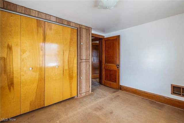 unfurnished bedroom featuring light colored carpet and a closet