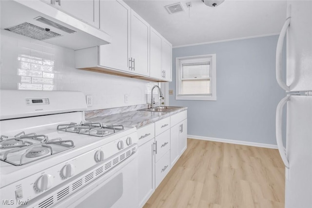 kitchen featuring light stone counters, white appliances, sink, and white cabinets