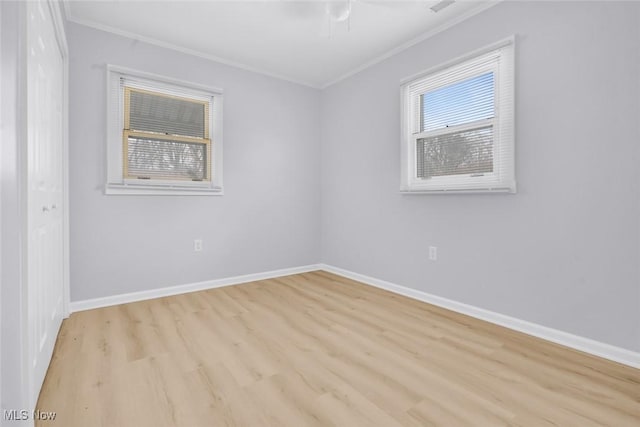 spare room featuring ornamental molding and light hardwood / wood-style flooring