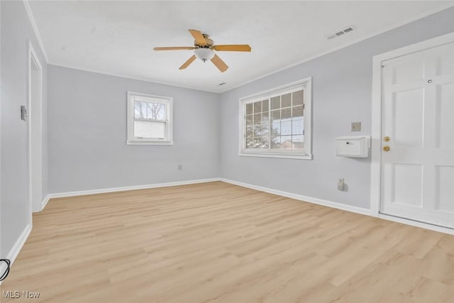 empty room featuring crown molding, light hardwood / wood-style floors, and ceiling fan