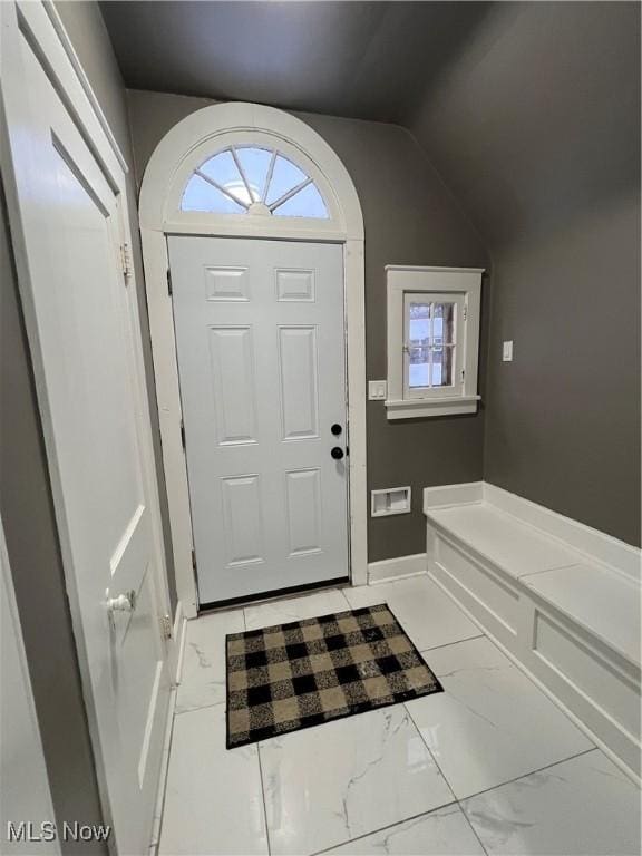 entrance foyer with vaulted ceiling, a healthy amount of sunlight, and marble finish floor