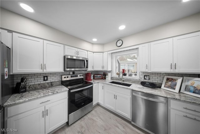 kitchen with white cabinetry, sink, tasteful backsplash, and appliances with stainless steel finishes