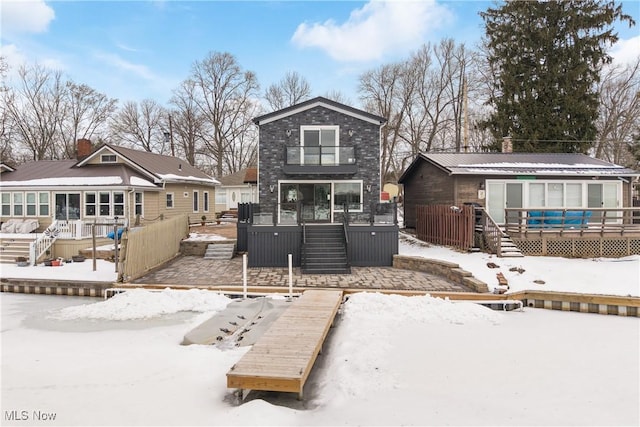 snow covered back of property with a wooden deck