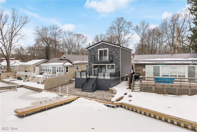 snow covered rear of property featuring a deck