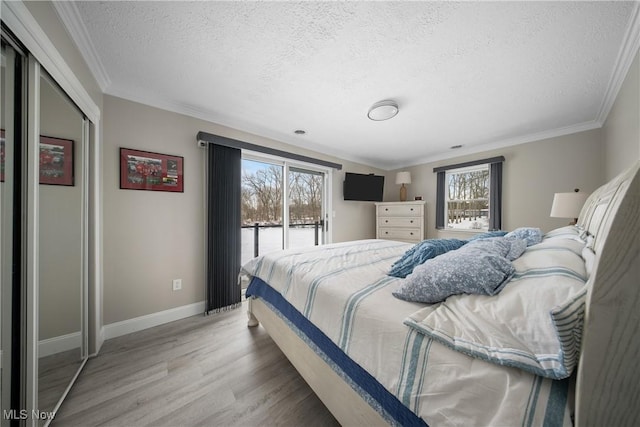 bedroom with hardwood / wood-style floors, ornamental molding, a textured ceiling, and access to exterior