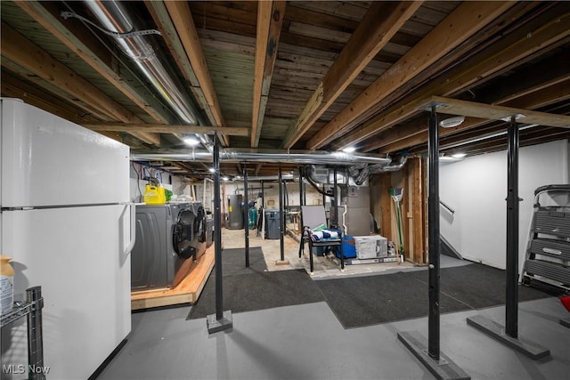 basement featuring water heater, white fridge, heating unit, and independent washer and dryer