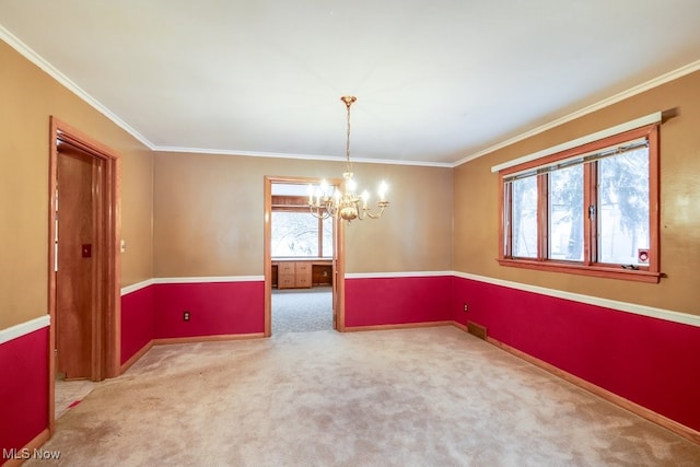 empty room featuring ornamental molding, carpet floors, and an inviting chandelier