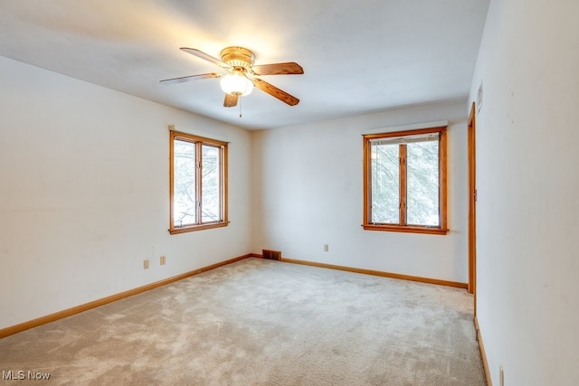 carpeted spare room featuring ceiling fan