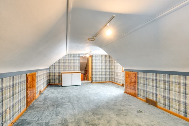 bonus room with lofted ceiling and carpet flooring