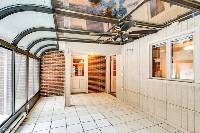 unfurnished sunroom featuring ceiling fan and vaulted ceiling