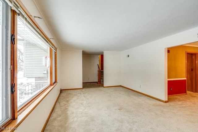 empty room with ornamental molding and light carpet