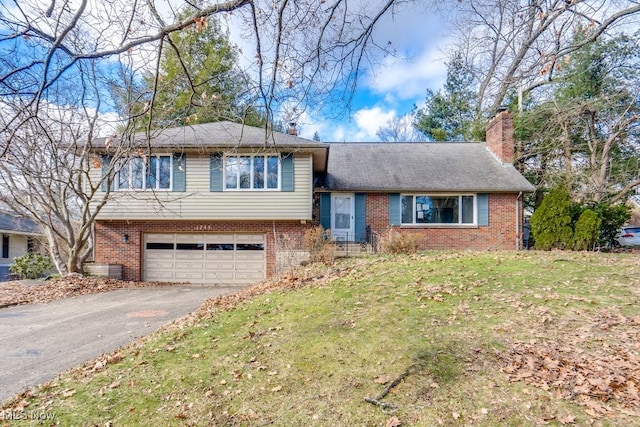 split level home featuring a garage and a front lawn