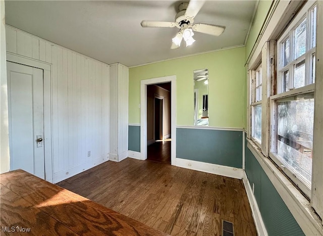 empty room with ceiling fan and dark hardwood / wood-style flooring