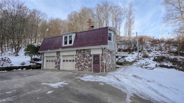 view of snow covered exterior featuring a garage