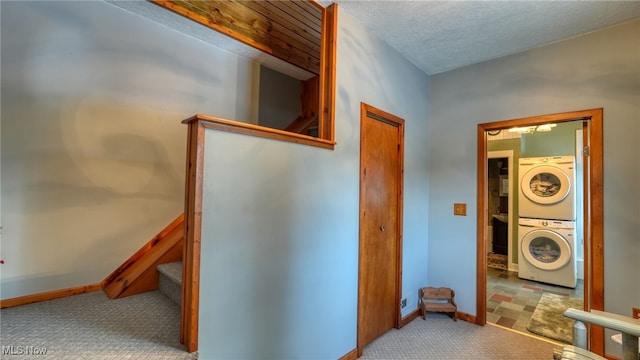 interior space featuring stacked washer / drying machine and a textured ceiling