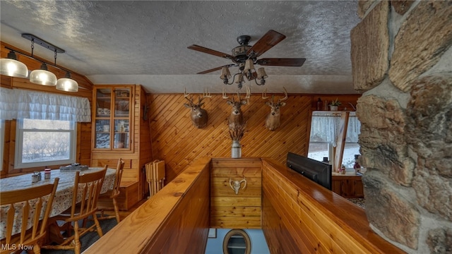 hallway with a textured ceiling and wood walls