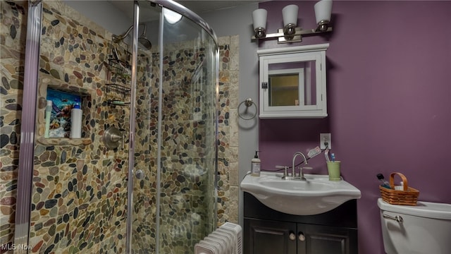 bathroom with walk in shower, radiator heating unit, toilet, and vanity