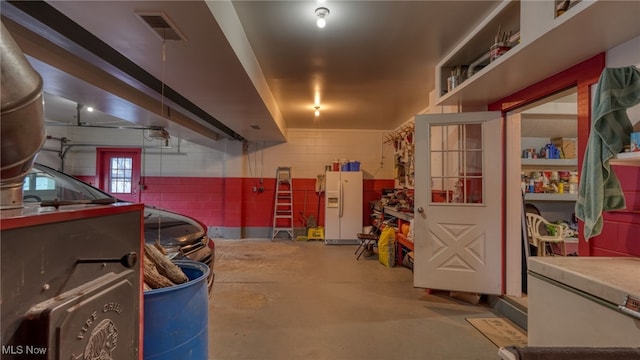 basement with white refrigerator with ice dispenser