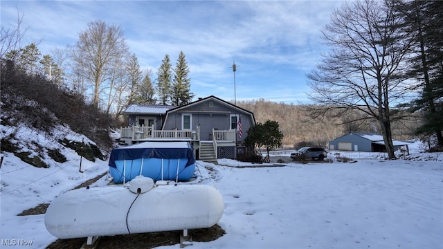 snow covered house featuring a swimming pool side deck