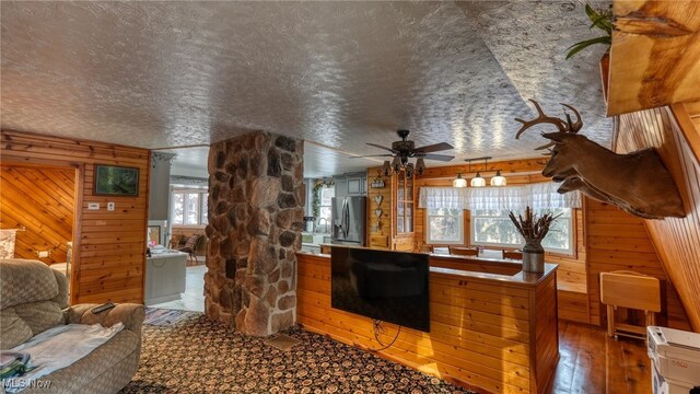 2250 Indian Camp Run Rd, New Concord, OH 43762 - living room with a textured ceiling, wood walls, ceiling fan, and hardwood / wood-style flooring