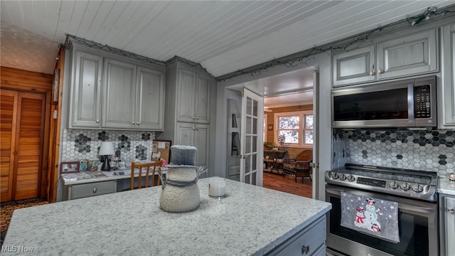 kitchen featuring tasteful backsplash, appliances with stainless steel finishes, gray cabinetry, and wooden ceiling