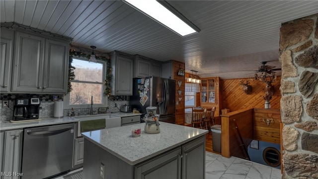 kitchen featuring stainless steel dishwasher, gray cabinets, a center island, and black refrigerator with ice dispenser