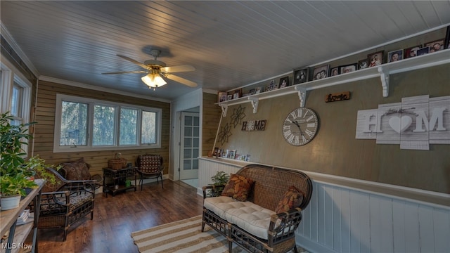 sitting room with crown molding, wooden ceiling, wooden walls, dark hardwood / wood-style flooring, and ceiling fan