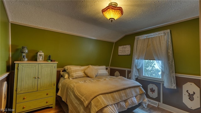 bedroom featuring lofted ceiling and a textured ceiling