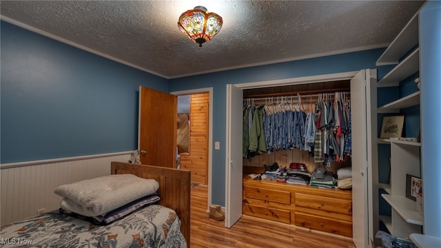 bedroom featuring hardwood / wood-style flooring, a closet, and a textured ceiling