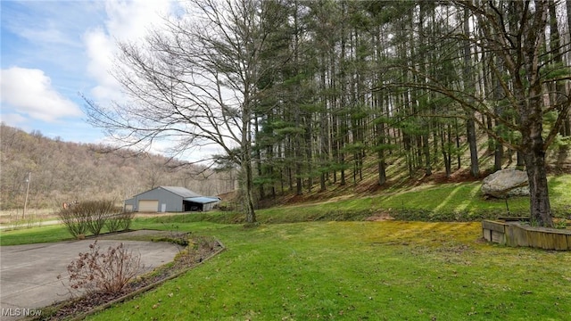 2250 Indian Camp Run Rd, New Concord, OH 43762 - view of yard with a view of trees, an outdoor structure, a garage, and concrete driveway