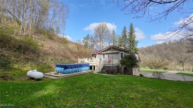 2250 Indian Camp Run Rd, New Concord, OH 43762 - view of yard with a wooden deck and a covered pool