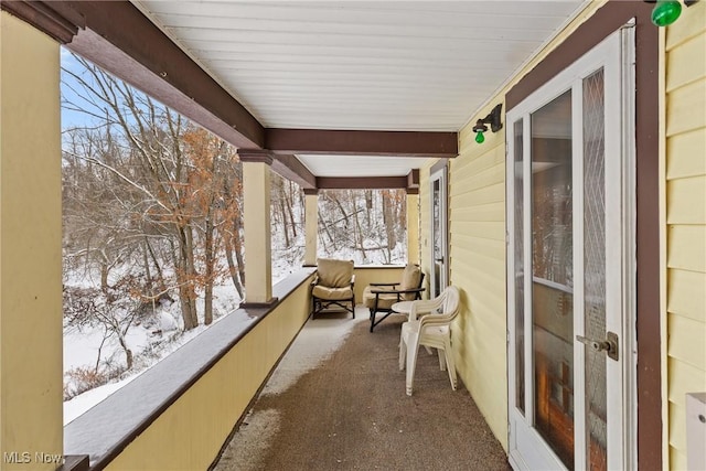 view of snow covered back of property