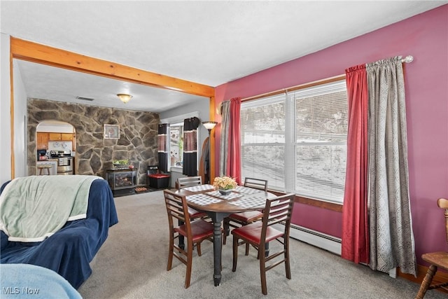 dining space with beamed ceiling, light colored carpet, a fireplace, and a baseboard radiator