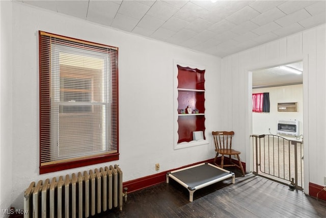 living area with radiator heating unit and dark hardwood / wood-style flooring