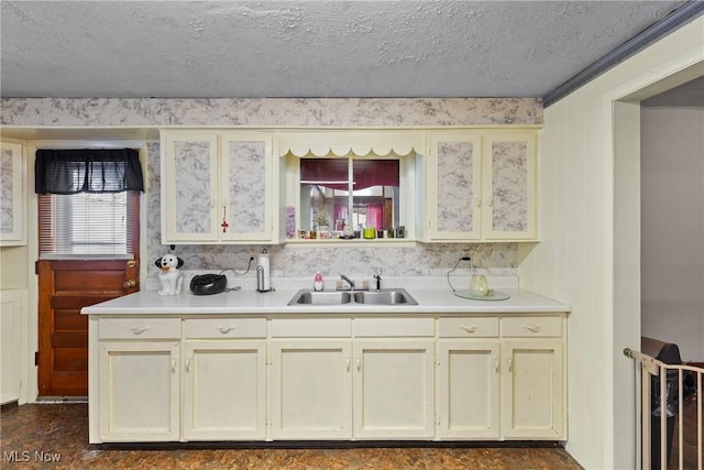 kitchen featuring sink, cream cabinetry, and a textured ceiling