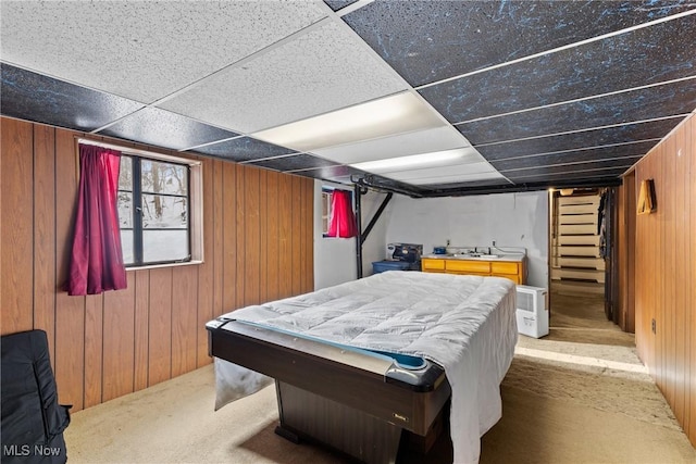 bedroom featuring wooden walls, sink, carpet flooring, pool table, and a drop ceiling