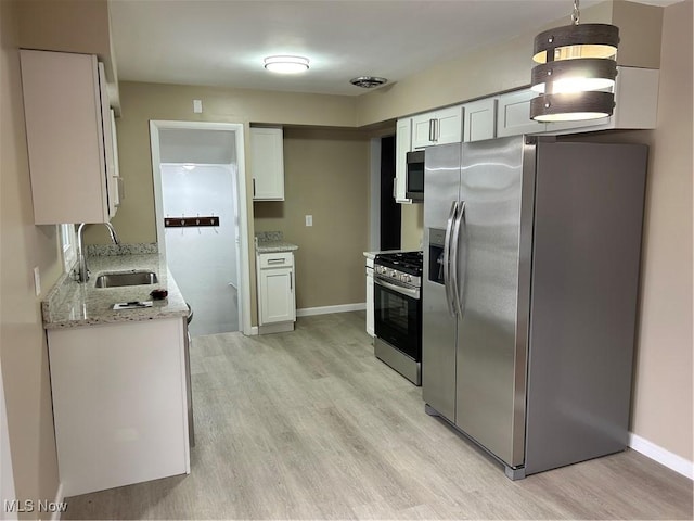 kitchen featuring sink, light wood-type flooring, white cabinets, and appliances with stainless steel finishes