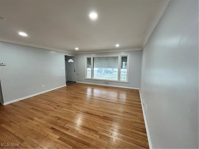 unfurnished room with crown molding and light hardwood / wood-style floors