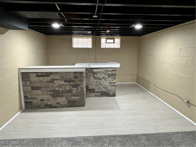 basement with hardwood / wood-style flooring and indoor bar