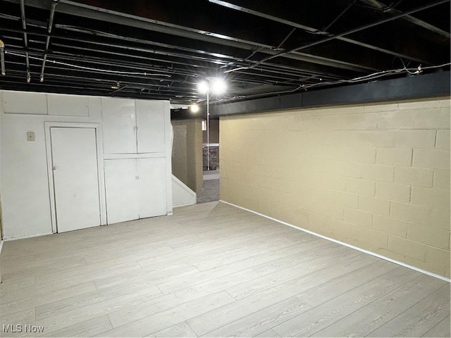 basement with hardwood / wood-style flooring