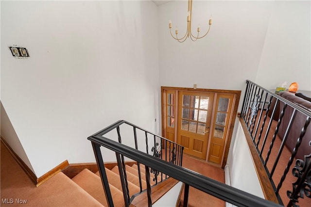 stairway featuring a chandelier and carpet