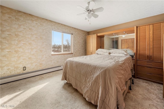 bedroom featuring baseboard heating, ceiling fan, and carpet floors